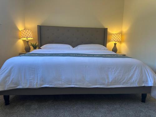 a bedroom with a large bed with two lamps at Downtown Private Master Suite in Sacramento