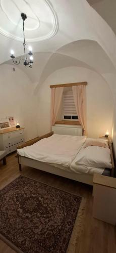 a bedroom with a large bed with a window at Dům u Kříže in Broumov