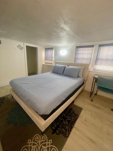 a bedroom with a large bed in a room with windows at Lower Level Luxury in Chicago