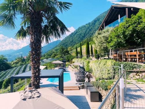 a resort with a palm tree and a swimming pool at Residence Pranterhof in Marlengo