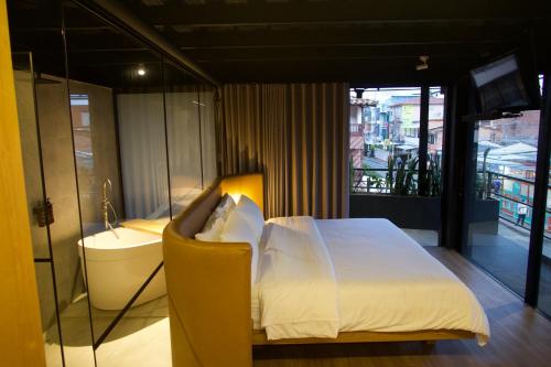 a bedroom with a bed and a tub and a sink at Casa Leon Hotel R Top in Rionegro