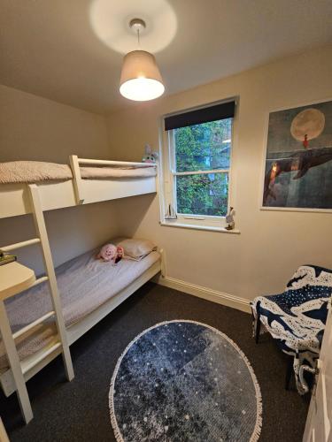 a bedroom with bunk beds and a window at Cosy 2 Bedroom Coastal Retreat with Sea Views and a Private Indoor Hot Tub in Margate