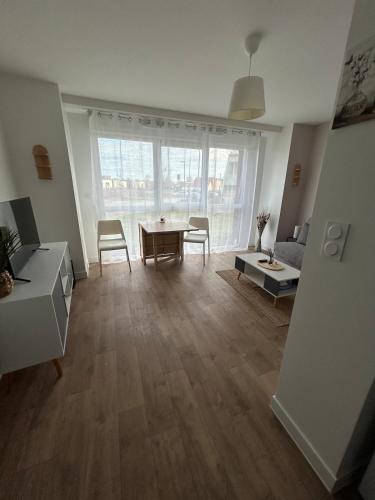 a living room with a table and a couch at Le cocon de Joëly in Rosières-près-Troyes