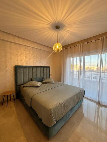 a bedroom with a large bed and a chandelier at Luxury By Sana in Agadir