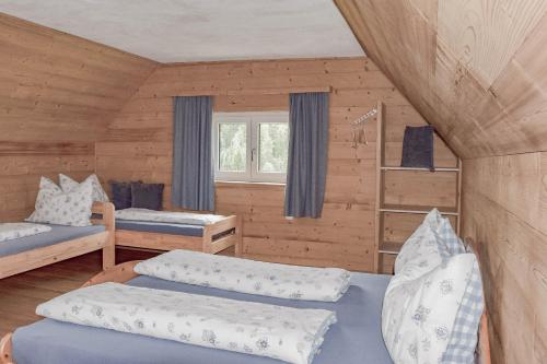 a room with two beds in a log cabin at Biobauernhof Gegg in Schwanberg