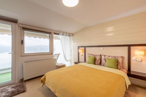 a bedroom with a large yellow bed with green pillows at Lakeview Sunset Kastoria in Kastoria