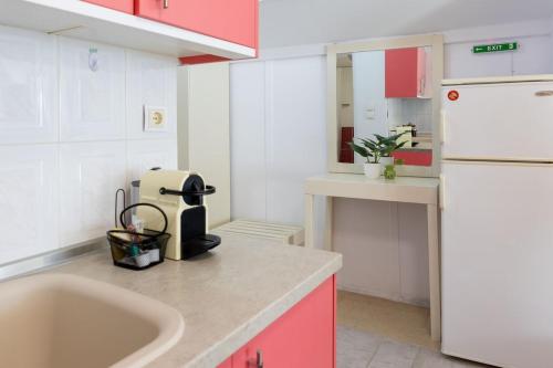 a kitchen with pink cabinets and a white refrigerator at Lakeview Sunset Kastoria in Kastoria