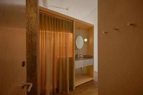 a bathroom with a shower curtain and a sink at Pocketbook Hotel and Baths in Hudson