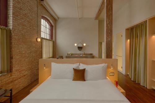 a bedroom with a large bed with white pillows at Pocketbook Hotel and Baths in Hudson