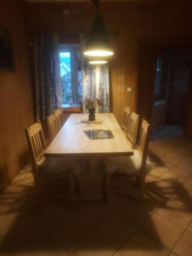 a dining room table with chairs and a light at Gamlevegen in Fagernes