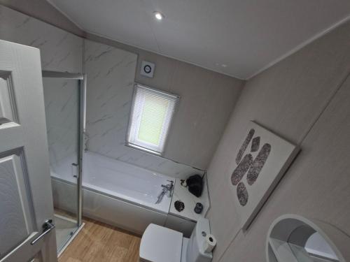 a bathroom with a shower and a tub and a toilet at Sherwood 33 in Carnforth
