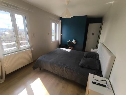 a bedroom with a large bed and two windows at Notre Dame d'Orgemont - Bleu Nuit 4 in Argenteuil