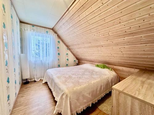a bedroom with a wooden wall with a bed at Arctic Getaway Sørvågen - King Crab Welcome Gift in Sørvågen