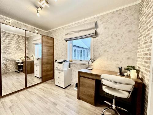 a bathroom with a desk and a chair in it at Arctic Getaway Sørvågen - King Crab Welcome Gift in Sørvågen