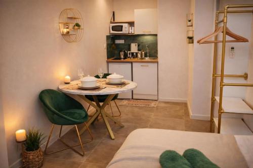 a small kitchen with a table and chairs in a room at La Chic Opéra - à 30 secondes min du Vieux-Port- Clim in Marseille