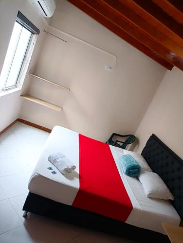 a bedroom with a bed with a red and white quilt at Hotel Picasso 70 in Medellín