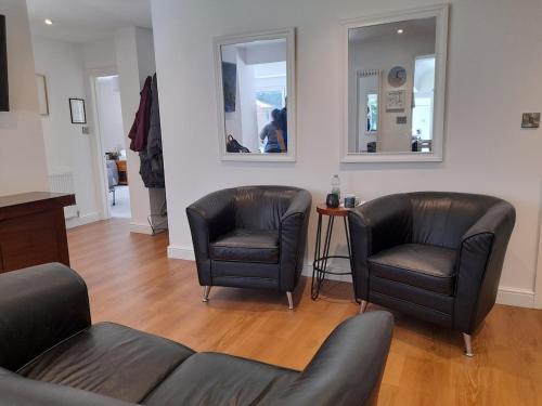 a living room with two chairs and two mirrors at Peaceful Room Overlooking Nature & Parking in Bloxwich