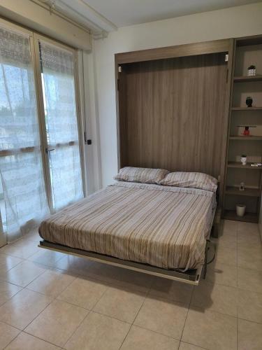 a bedroom with a bed with a wooden headboard at Casa dei Mazzoni in Crema