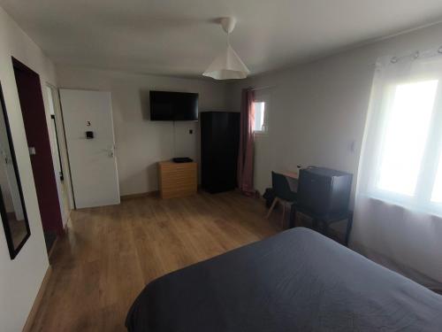 a bedroom with a bed and a television in it at Notre Dame d'Orgemont - Rose 3 in Argenteuil