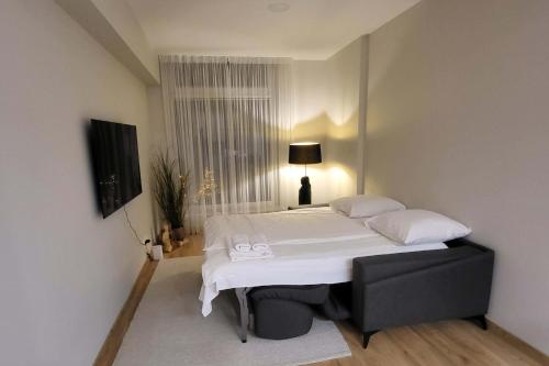 a bedroom with a white bed and a window at To Be Apartament Palanga in Palanga