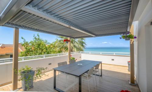 een terras met een tafel en uitzicht op de oceaan bij Naias in Hanioti