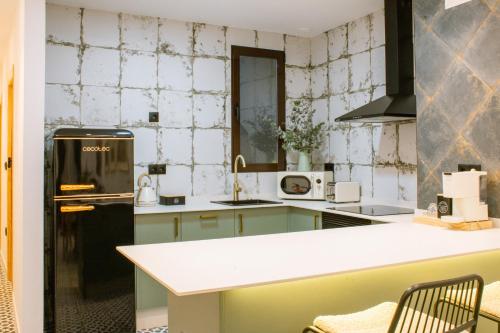 a kitchen with a green and white tiled wall at Apartamentos Princesa Hayla in Caravaca de la Cruz