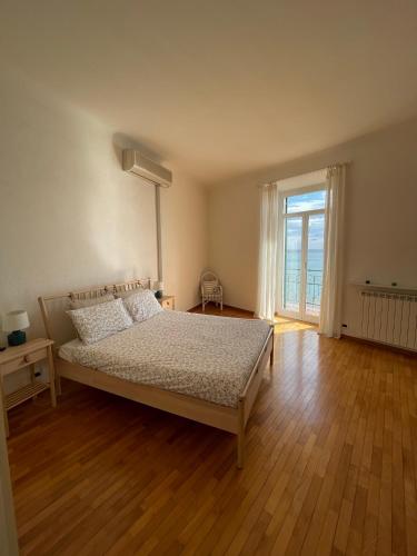 a bedroom with a bed and a large window at CasAmare di Carla in Savona
