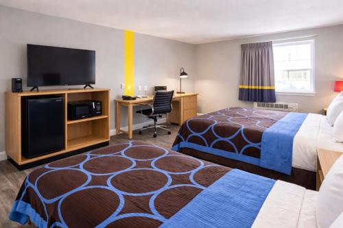 a hotel room with two beds and a flat screen tv at Super 8 by Wyndham Lewiston in Lewiston