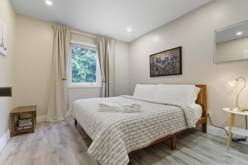 a bedroom with a bed with two towels on it at Spruce Suite Historic NOTL - VINEYARD RETREAT in Niagara-on-the-Lake