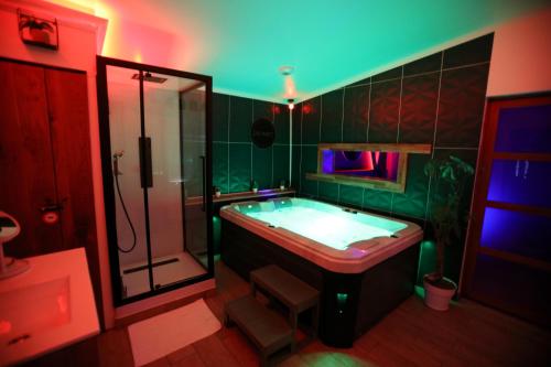 a large bathroom with a tub and a shower at Loveroom L'1TIMISTE CDS in Neuilly-Plaisance
