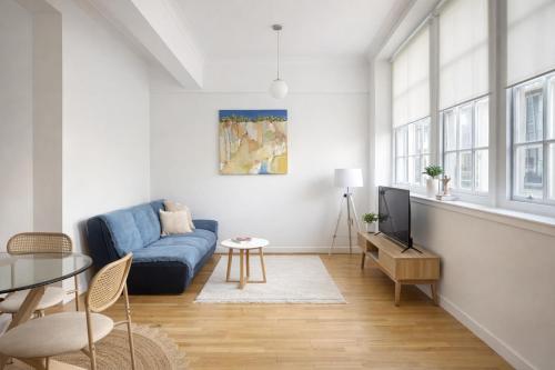a living room with a blue couch and a tv at Luxury Historic City-Centre Flat & Free Parking in Glasgow