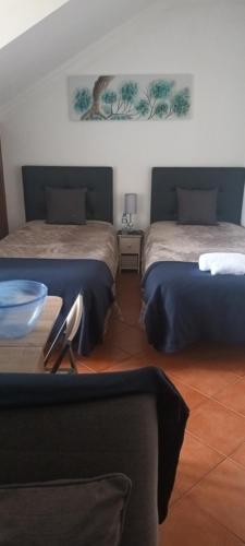 ein Schlafzimmer mit zwei Betten und einem Tisch mit einer Schüssel darauf in der Unterkunft Ocean Studio in Peniche