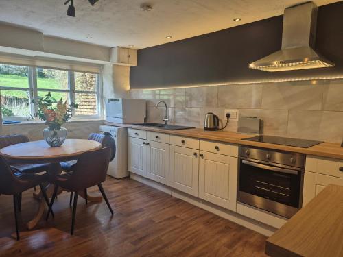 a kitchen with a table and a sink and a stove at Underhill Holiday Cottage in Whitby