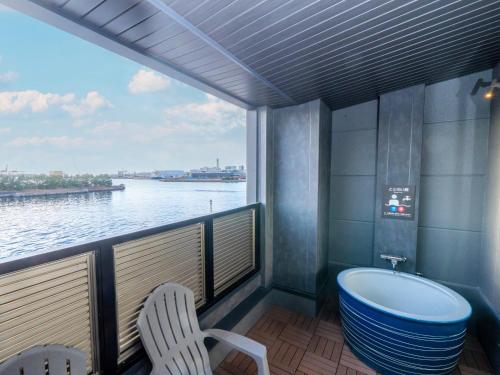 a balcony with a tub and a view of the water at Kanohotel and Cabin Chiba Soga in Chiba