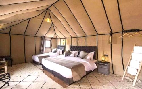 a bedroom with a bed in a tent at Sahara Imperial Luxury Camp in Merzouga