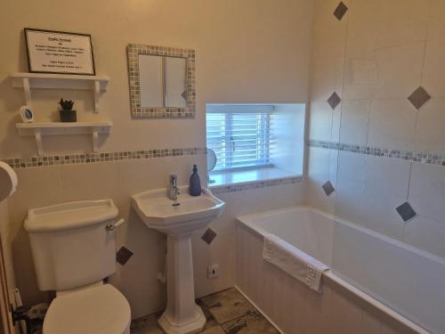 a bathroom with a toilet and a sink and a tub at Underhill Holiday Cottage in Whitby