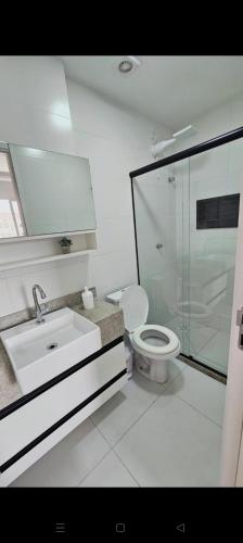 a bathroom with a toilet and a sink and a shower at Apê Morabeza in Vila Velha