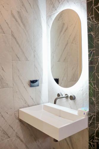 a bathroom with a white sink and a mirror at Baby Blue pool villa in Ban Bo Prakhon