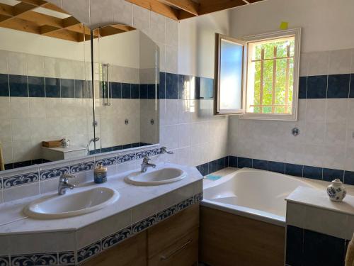 a bathroom with two sinks and a bath tub at la passerelle du couchant in Langlade