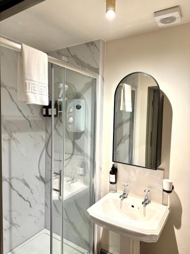 a bathroom with a sink and a shower with a mirror at Piccadilly Central in Manchester