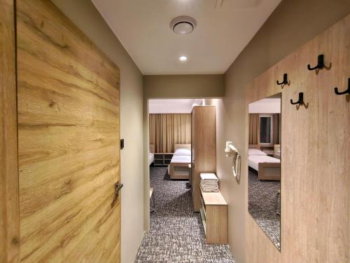 a room with two beds and a door with a mirror at Pensione Antonio - Klimatyzowane Pokoje, Centrum Słupska, Spokojny Hotel in Słupsk