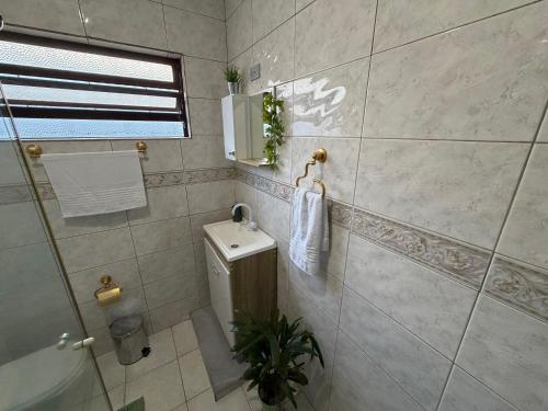 a bathroom with a toilet and a sink and a shower at Triana Guest House in Foz do Iguaçu
