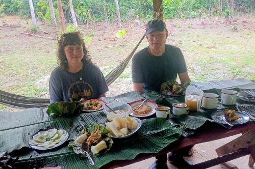 a man and woman sitting at a table with food at Panguana Lodge all included in Iquitos