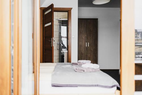 a mirror with towels on a bed in a room at Pod Limbami in Poronin