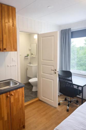 a bathroom with a sink and a chair in a room at Kristiansund Airport Motell in Kristiansund