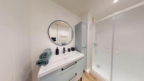 a white bathroom with a sink and a mirror at "HORIZON BLEU" - en bord de Mer in Port-de-Bouc