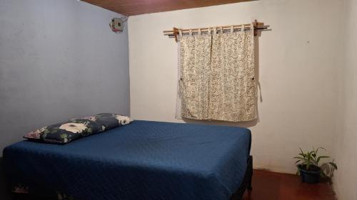 a bedroom with a blue bed and a window at Casa Mary in Panajachel