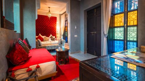a living room with a red bed in a room at Riad Sultan Suleiman & Spa in Marrakesh