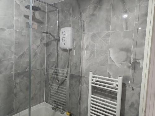 a shower with a glass door in a bathroom at Thames Riverside Studio, Gravesend Town Centre - near train station in Gravesend