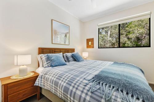a bedroom with a bed and a window at Baden 74 Rainbow Shores in Rainbow Beach